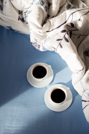 two cups of coffee in bed, sunlightの写真素材
