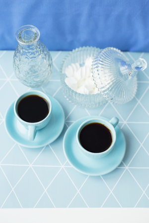 Beautiful composition - coffee, saucer and bowl of marshmallows in geometrical napkinの写真素材