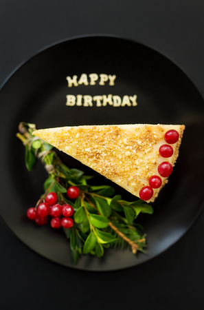 cake decorated Christmas tree branch and red berries, inscription happy birthdayの写真素材