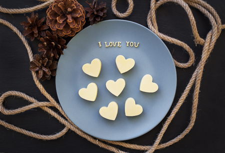 candy white chocolate in a heart, I love writing on a blue plate with conesの写真素材