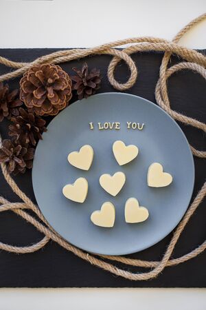 candy white chocolate in a heart, I love writing on a blue plate with conesの写真素材