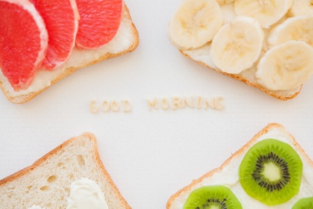 bright mix of sandwiches for breakfast (fruit, vegetables, fish) inscription good morningの写真素材