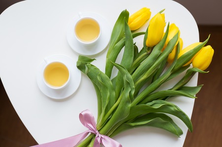 beautiful yellow tulips, two cups of green tea, springの写真素材