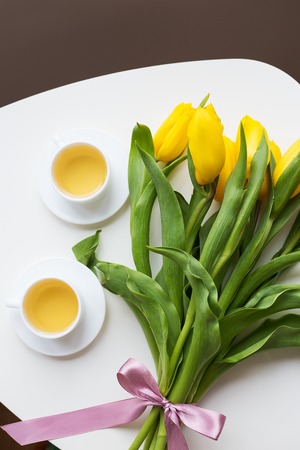 beautiful yellow tulips, two cups of green tea, springの写真素材