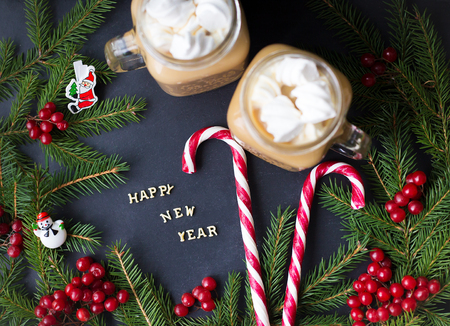 A cup of coffee with marshmallows, candies and Christmas decorations.の写真素材