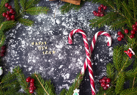 Christmas or New Year decoration background. For tree branches, candy on black background.の写真素材
