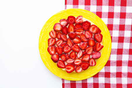 Bright and delicious strawberry cake on a red napkin in a cage.の写真素材