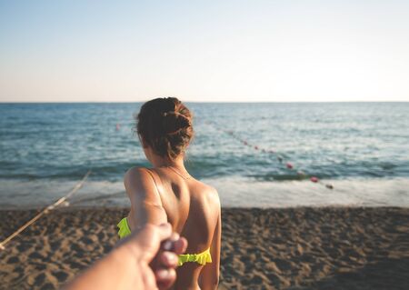 Girl at the sea holding the hand of Man.の写真素材