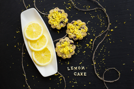 lemon cupcakes on a black background with lemon zest, lemon cake inscriptionの写真素材