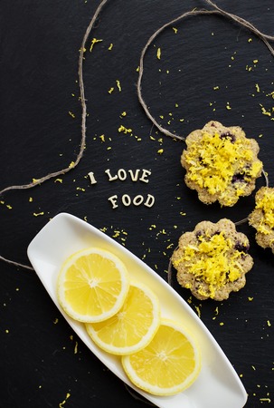 lemon cupcakes on a black background with lemon zest, inscription, I love foodの写真素材