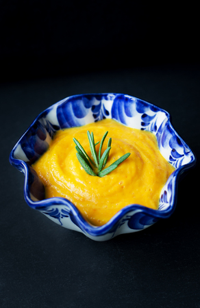 pumpkin soup in a blue plate on a black background.の写真素材