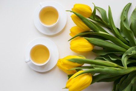 beautiful yellow tulips, two cups of green tea, springの写真素材