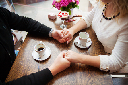 dessert with words of love and a cherry on a background of couples with coffee.の写真素材