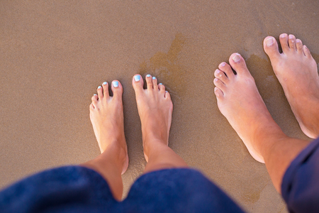 Feet of two lovers on sand-summer, sun, sea, beachの写真素材