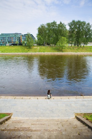 Beautiful girl sits and looks at the river Vilnius - Lithuania.の写真素材
