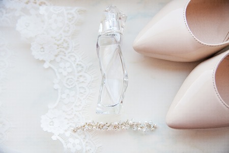beautiful wedding accessories. Bride shoes, perfumes on a white veil.の写真素材