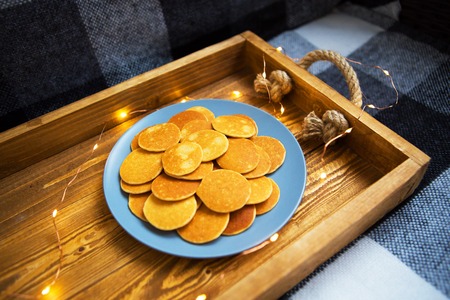 a plate of punkcakes lies on a wooden tray with lights.の写真素材