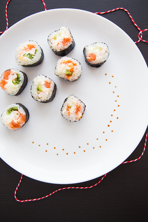 Delicious fresh sushi on a white plate, dark table. Close-upの写真素材