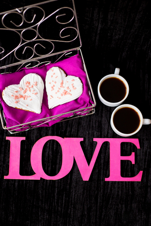 two cups of coffee, cookies in the form of heart inscription love close-up.の写真素材