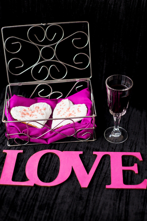 glass of wine, cookies in the form of heart inscription love close-up.の写真素材