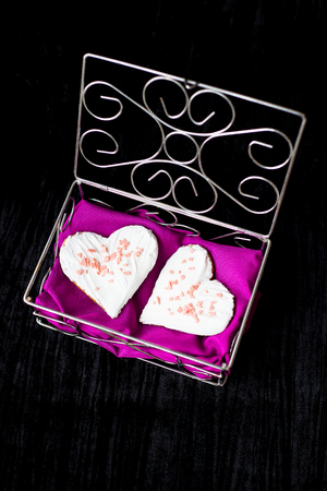 Cookies in the form of heart lies in a casket with a pink towel, close-up.の写真素材