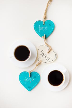 two cups of coffee on the table that says home.の写真素材
