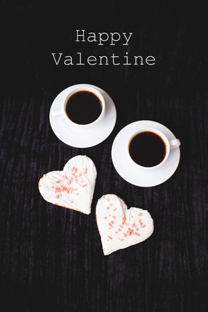 two cups of coffee and biscuits in the form of heart inscription Happy Valentine.の写真素材