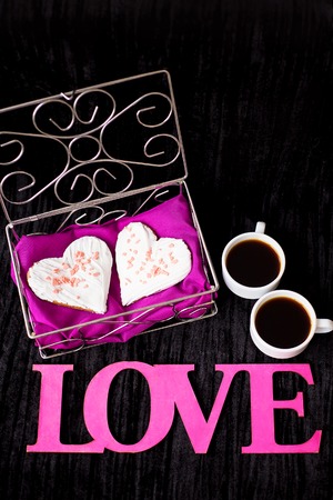two cups of coffee, cookies in the form of heart inscription love.の写真素材