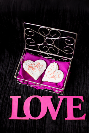 Cookies in the form of heart lies in a casket inscription love close-up.の写真素材