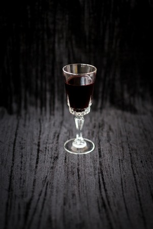 glass of red wine on a black velvet background, close-up.の写真素材