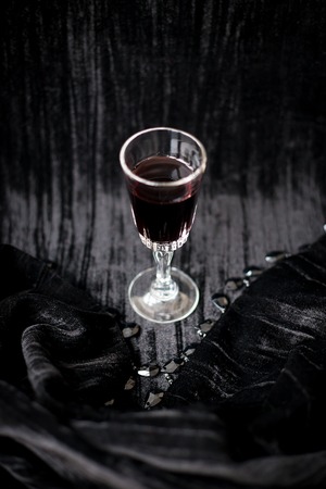 glass of red wine on a black velvet background, close-up.の写真素材