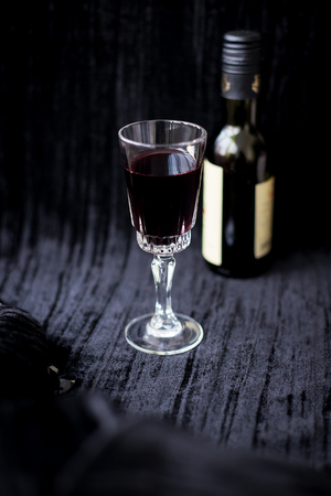 glass of red wine on a black velvet background, close-up.の写真素材