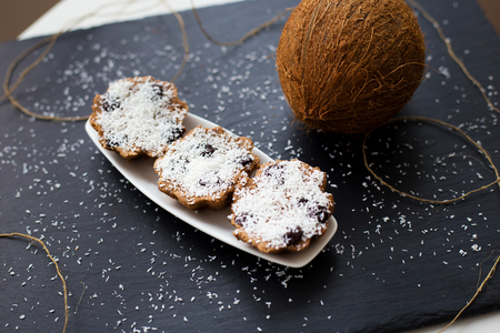 coconut muffins with chocolate on a black background and whole coconutの写真素材