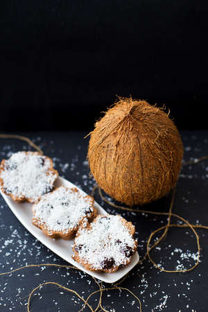 coconut muffins on a white plate with a whole coconut, close upの写真素材