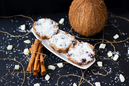 coconut muffins on a black background with cinnamon sticks and whole coconutの写真素材