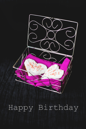 Cookies in the form of heart lies in a casket with a pink towel - inscription happy birthday.の写真素材