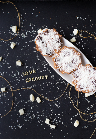coconut muffins on a black background with words like candied fruits and coconutsの写真素材