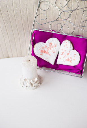 candle and biscuits in the form of heart on a pink napkin.の写真素材