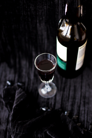 bottle and a glass of red wine on a black background.の写真素材