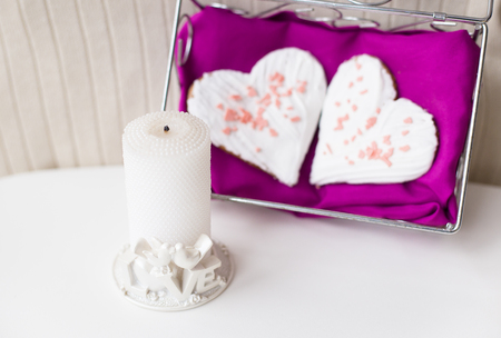 candle and biscuits in the form of heart on a pink napkin.の写真素材