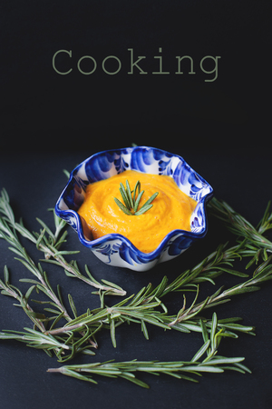 pumpkin soup in a blue plate on a black background, the inscription cookingの写真素材