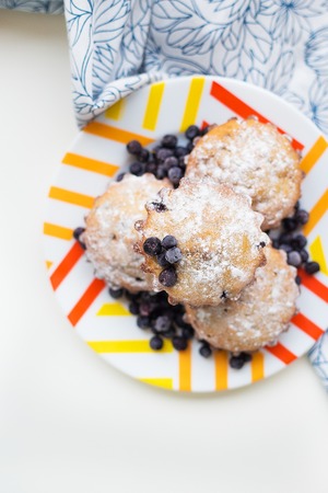 Blueberry muffins on plate and bright floral clothの写真素材