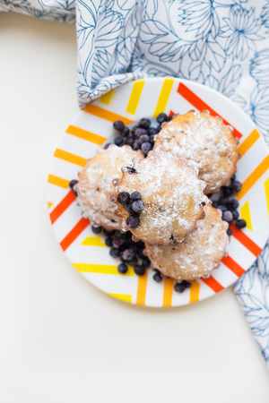 Blueberry muffins on plate and bright floral napkin, close-upの写真素材
