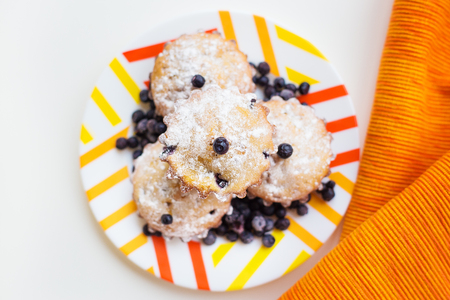 Blueberry muffins on a napkin and bright orange plateの写真素材