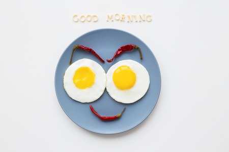 cheerful breakfast, two eggs on a plate, the inscription Good Morningの写真素材