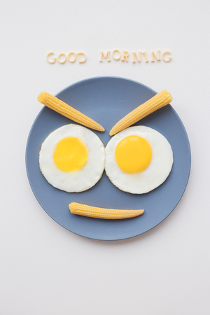 cheerful breakfast, two eggs on a plate, the inscription Good Morningの写真素材