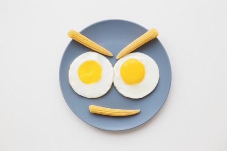 cheerful breakfast, two funny eggs on a plateの写真素材