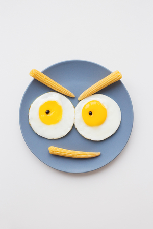cheerful breakfast, two funny eggs on a plateの写真素材
