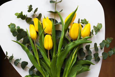 Beautiful yellow tulips on a white tableの写真素材