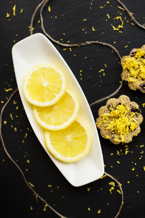 lemon cupcakes on a black background with lemon zestの写真素材